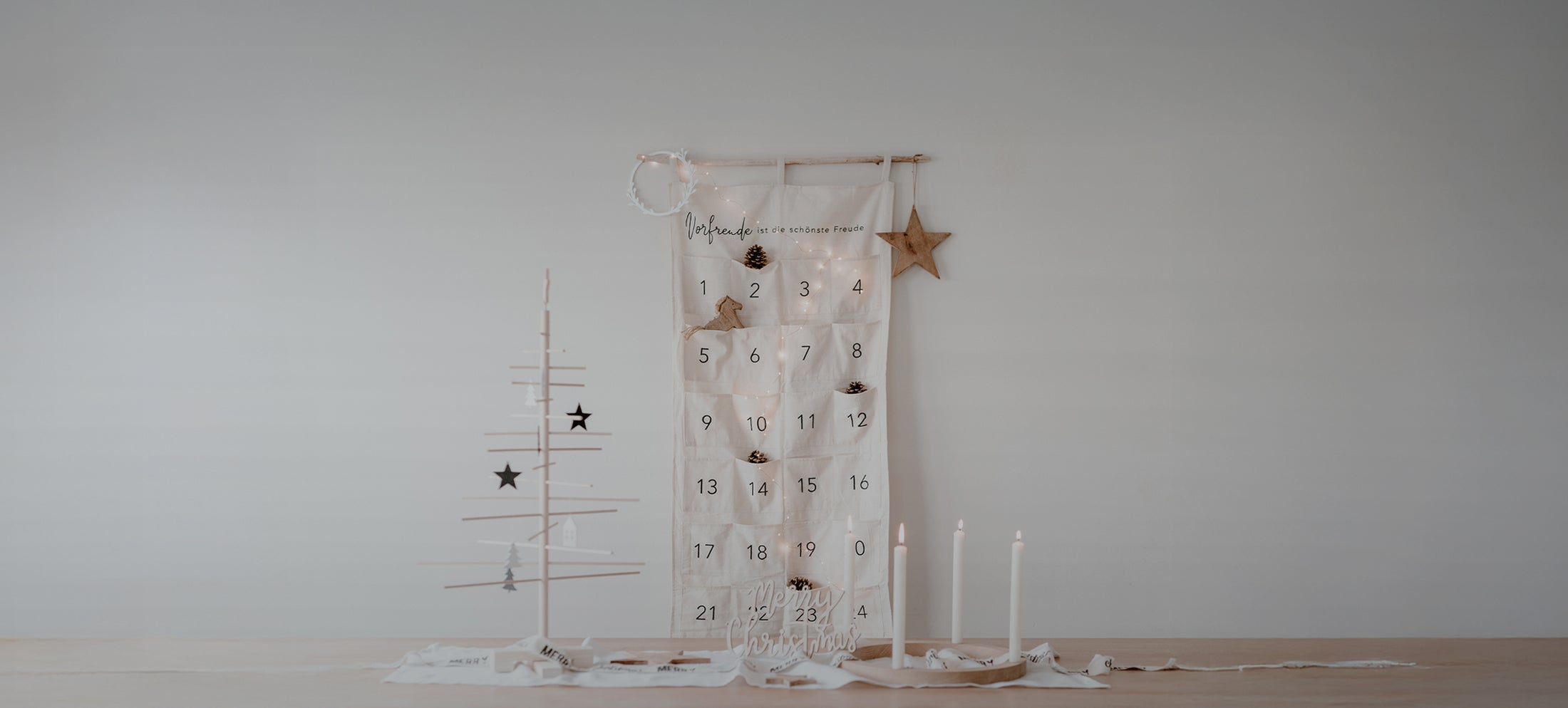 Minimalistisch gestalteter Adventskalender aus Stoff mit 24 Taschen. Oben auf dem Kalender steht: ‚Vorfreude ist die schönste Freude‘. Auf der Schaltfläche darunter steht: ‚Adventskalender‘