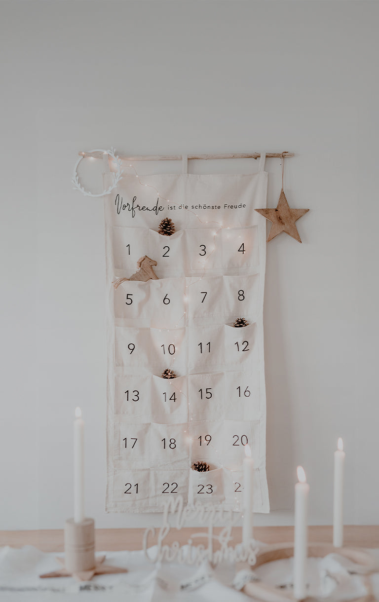 Minimalistisch gestalteter Adventskalender aus Stoff mit 24 Taschen. Oben auf dem Kalender steht: ‚Vorfreude ist die schönste Freude‘. Auf der Schaltfläche darunter steht: ‚Adventskalender‘